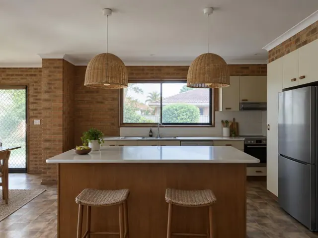 Two woven pendant lights over a kitchen island in a brick-walled home in Brookvale